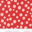 a close-up view of a red fabric with white polka dots. The fabric appears to be a part of a larger textile or garment, as indicated by the ruler for scale.