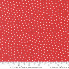 a red fabric with white hearts scattered across it.