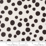a close-up view of a fabric with a black and white polka dot pattern. The fabric is white with numerous black polka dots scattered across it. There is a ruler placed at the bottom of the image, indicating the size of the fabric.