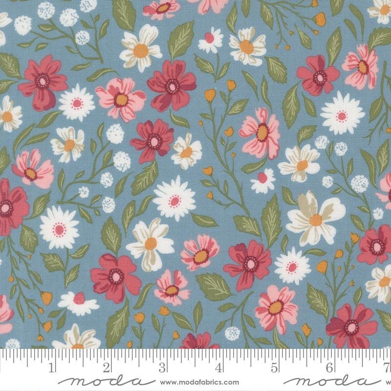 The image is a fabric with a floral pattern featuring various types of flowers in different colors, including red, white, and pink. The flowers are arranged in a repeating pattern, creating a visually appealing and vibrant design.