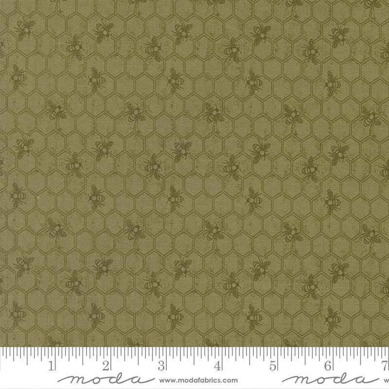 The image is a close-up of a fabric with a repeating pattern of hexagons and small bee images.