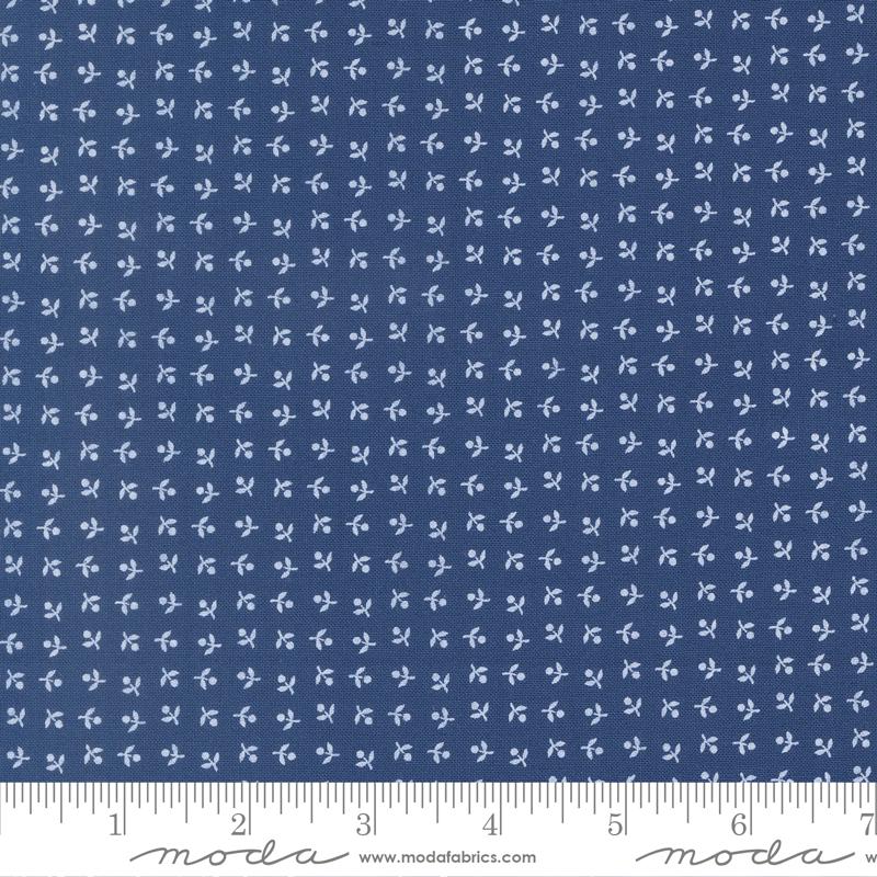 The image is a close-up of a fabric with a repeating pattern of small white flowers or leaves. The fabric appears to be navy blue in color.