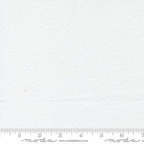 The image is a plain white fabric with small white dots, and it is being measured for size.