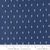 a close-up view of a fabric with a repeating pattern of small white dots on a dark blue background.