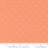 The image is a fabric with a repeating pattern of small white crosses or dots on an orange background.