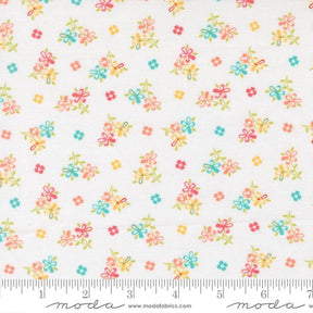 The image is a fabric with a floral pattern, featuring small colorful flowers and leaves scattered across it.