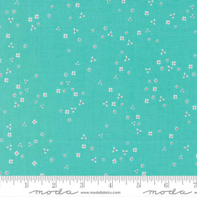 The image is a fabric with a teal green background and small white flowers scattered across it.