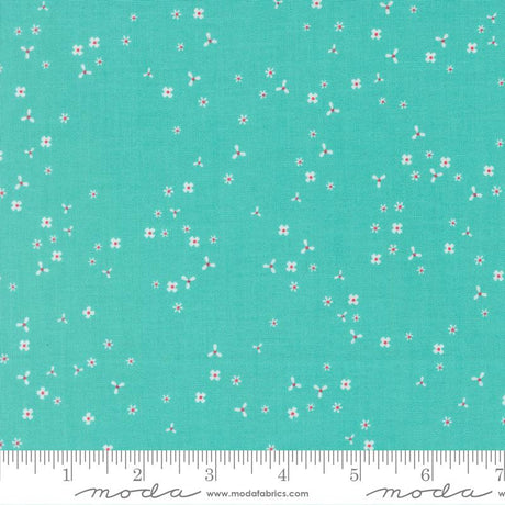 The image is a fabric with a teal green background and small white flowers scattered across it.
