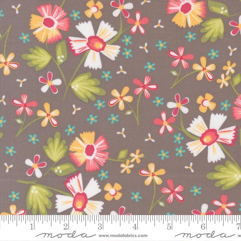 The image is a fabric with a floral pattern, featuring various colorful flowers and leaves in shades of green, yellow, pink, and orange. The fabric appears to be a dark brown color, providing a contrast to the vibrant colors of the flowers. The image is a close-up view of the fabric, showcasing the intricate details and patterns of the floral design.