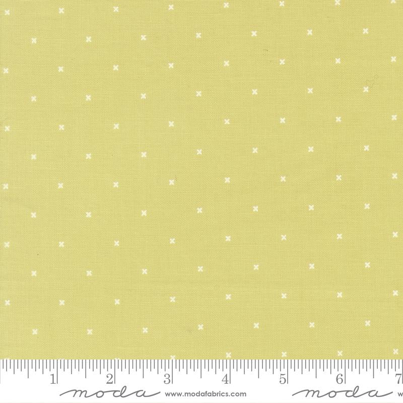 The image is a fabric with a yellow background and white dotted pattern. There is a ruler at the bottom of the image for scale.