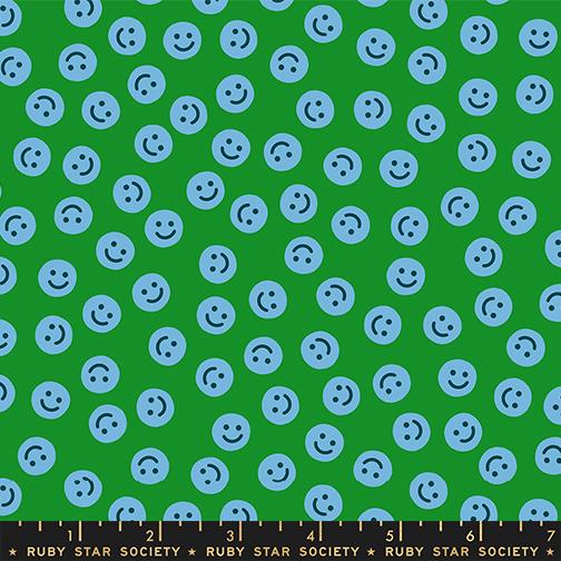 a pattern of blue smiley faces scattered across a green background.