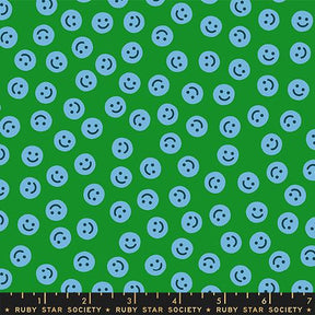a pattern of blue smiley faces scattered across a green background.