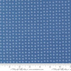 The image is a close-up of a fabric with a blue pattern, featuring small white dots or flowers arranged in a grid-like pattern.