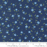 a fabric with a repeating pattern of blue flowers and green leaves on a dark blue background.