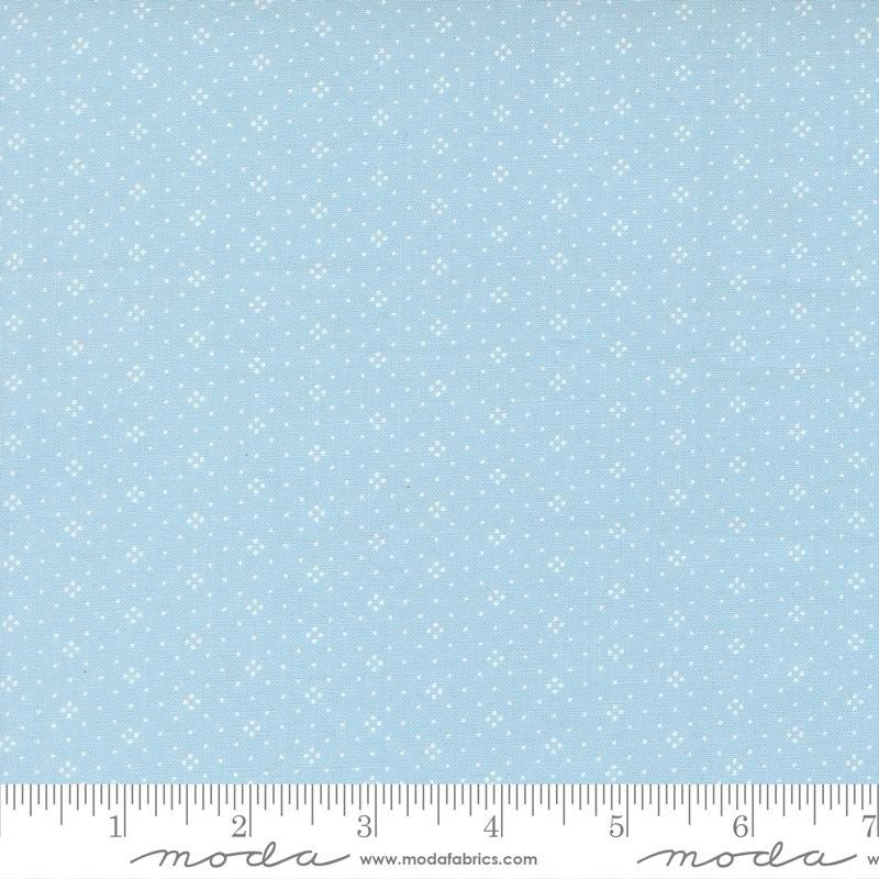 The image is a fabric with a light blue background with small white dots or stars arranged in a pattern.