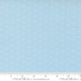 The image is a fabric with a light blue background with small white dots or stars arranged in a pattern.