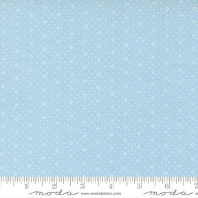 The image is a fabric with a light blue background with small white dots or stars arranged in a pattern.