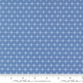 a blue fabric with a repeating pattern of white snowflakes. The fabric has a diagonal pattern of snowflakes, creating a visually appealing and festive design.