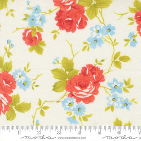 a close-up view of a fabric with a floral pattern of red roses and blue flowers. The roses are larger and more prominent, while the blue flowers are smaller and scattered throughout the fabric. The fabric appears to be a light-colored material, possibly cotton or linen, with a white background. The image does not contain any text or additional objects, and the focus is solely on the floral pattern.