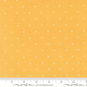 The image is a fabric with a yellow background and white dotted pattern.