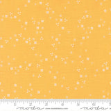 The image is a fabric with a yellow background and small white flowers scattered across it.