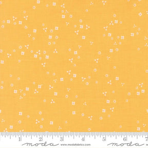 The image is a fabric with a yellow background and small white flowers scattered across it.