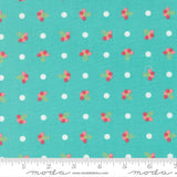a fabric with a repeating pattern of small white dots and pink flowers on a turquoise background.