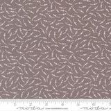The image is a fabric with a repeating pattern of small white dots or circles on a brown background.