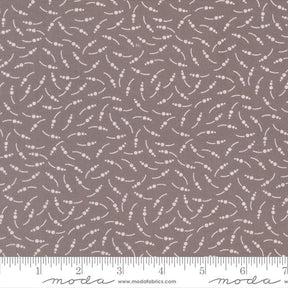 The image is a fabric with a repeating pattern of small white dots or circles on a brown background.
