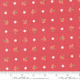 a red fabric with white polka dots and small green flowers printed on it. The fabric appears to be a part of a larger textile or garment, as indicated by the ruler for scale.
