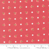 a red fabric with white polka dots and small green flowers printed on it. The fabric appears to be a part of a larger textile or garment, as indicated by the ruler for scale.