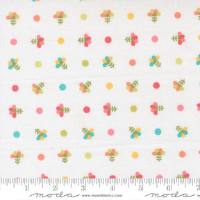 The image is a fabric with a repeating pattern of colorful flowers and polka dots.