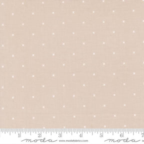 The image is a fabric with a light pink background and small white dots or stars scattered across it.