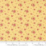The image is a close-up of a fabric with a repeating pattern of small red flowers on a yellow background.