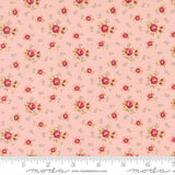 The image is a fabric with a repeating floral pattern in shades of pink and white. The pattern consists of small red flowers and leaves scattered across the fabric, creating a visually appealing and intricate design.
