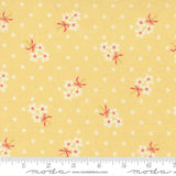 The image is a fabric with a yellow background and white polka dots, featuring small white flowers with pink bows.