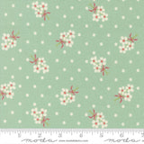 a fabric with a repeating pattern of white flowers with red bows against a light green background with white polka dots.