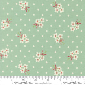 a fabric with a repeating pattern of white flowers with red bows against a light green background with white polka dots.