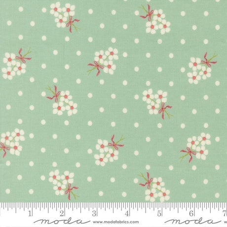 a fabric with a repeating pattern of white flowers with red bows against a light green background with white polka dots.