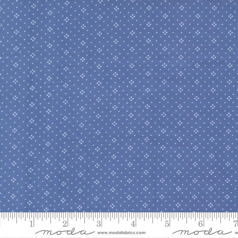 The image is a close-up of a fabric with a blue background and white dots or stars arranged in a pattern.