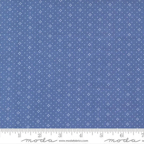 The image is a close-up of a fabric with a blue background and white dots or stars arranged in a pattern.