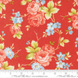 a vibrant red fabric adorned with a floral pattern of pink roses and blue flowers. The fabric is displayed on a ruler for scale, indicating its size.