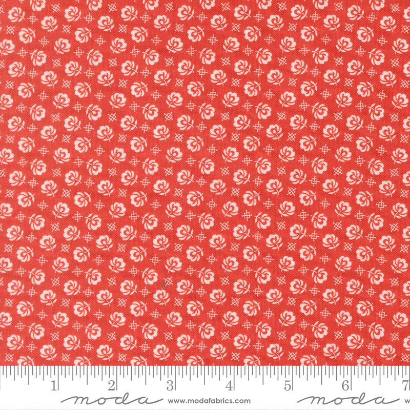 The image is a red fabric with a repeating pattern of white flowers or leaves. The pattern is evenly spaced and covers the entire fabric.