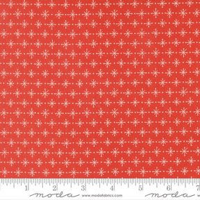 a red fabric with a repeating pattern of white snowflakes. The fabric has a ruler at the bottom to provide a scale for the image.