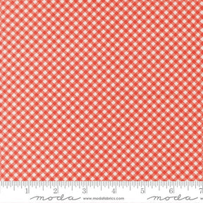 a close-up view of a fabric with a red and white checkered pattern. The fabric appears to be made of a material with a grid-like texture, which creates a repeating pattern of small squares or rectangles. The fabric is displayed against a ruler for scale, indicating its size.