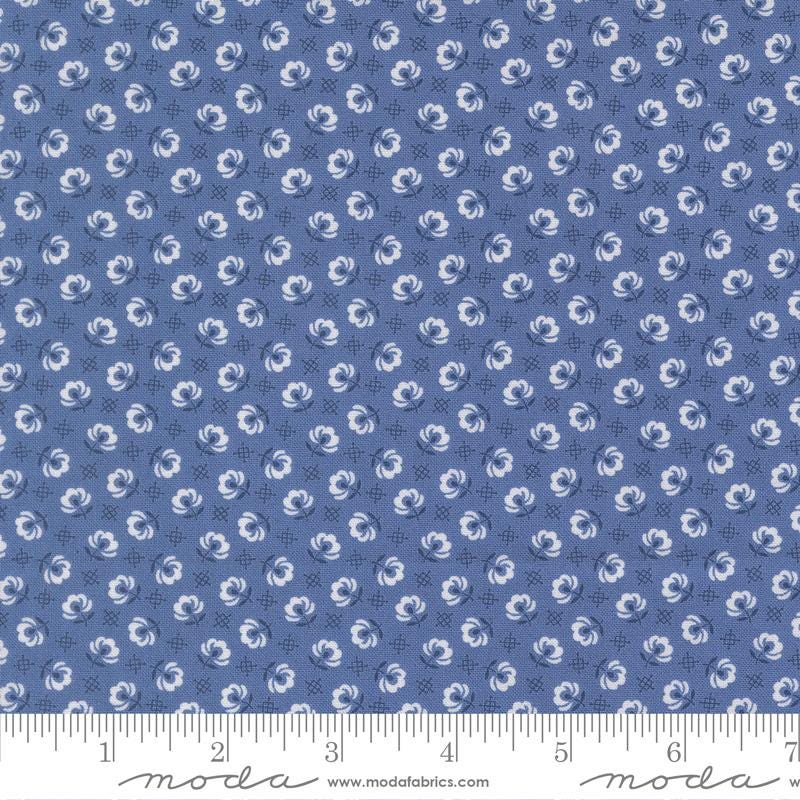 a fabric with a repeating pattern of blue flowers on a dark blue background. The pattern consists of small white flowers arranged in a grid-like fashion, creating a visually appealing and intricate design.