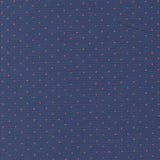 a close-up view of a fabric with a pattern of small red dots against a navy blue background.