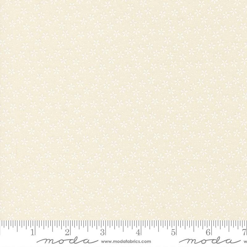 The image is a fabric with a repeating pattern of small white flowers or dots. The fabric appears to be light beige in color.