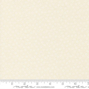 The image is a fabric with a repeating pattern of small white flowers or dots. The fabric appears to be light beige in color.