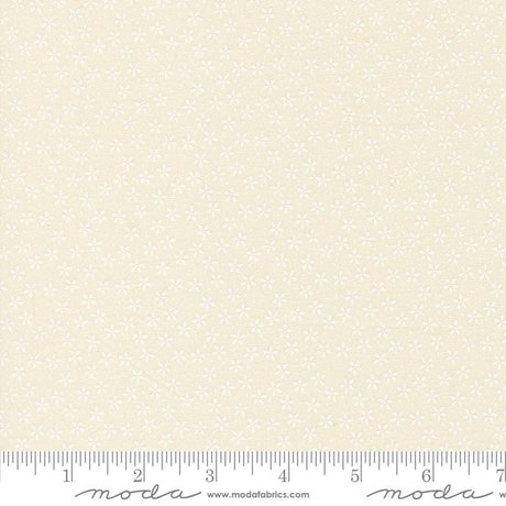 The image is a fabric with a repeating pattern of small white flowers or dots. The fabric appears to be light beige in color.